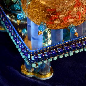 Detail von Glasobjekt mit gehäkelter Bronze, Glaselementen, Feingold und Licht